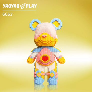 A Brick Bear toy with light blue ears, gradient pink-yellow face, and red heart chest, labeled "6652PCS" on a yellow backdrop.