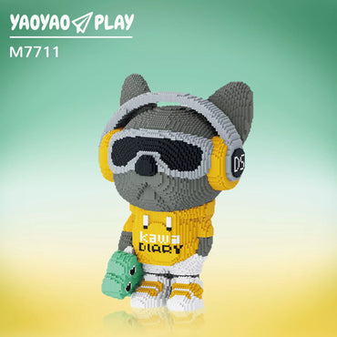A stylized Brick Bear toy with gray headphones, black goggles, and a "kawa DIARY" T-shirt, set against a teal-to-yellow gradient
