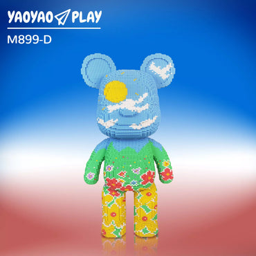 The M899-D model Brick Bear toy, featuring interlocking building blocks in green, yellow, and red floral patterns, set against a gradient blue-to-red background.