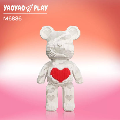 A ​​Brick Bear toy​​ made from recycled ​​building blocks​​, paired with a kraft paper bag labeled "100% Ecographik."